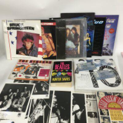 A box of music memorabilia comprising tour programs for Paul Weller (with tickets), Bruce Springsteen and others plus a Pink Floyd baseball cap, some Supertramp publicity prints, books etc.