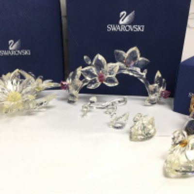 A collection of Swarovski including boxed Orchids on vine ( part needs re gluing ) , Maxi Flower, Christmas bell ornament, swans . This lot cannot be posted