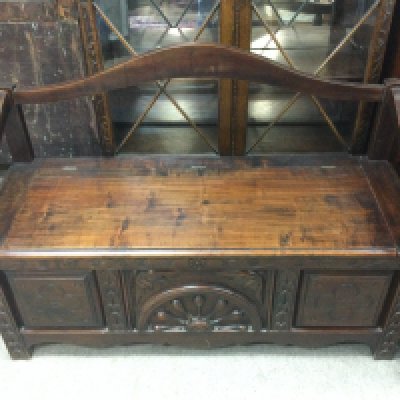 An Oak settle with carved design . Dimensions 122cm wide 85cm tall