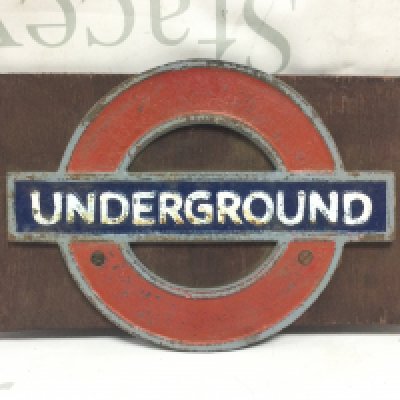 A small heavy metal sign for London Underground on wood , wood 35.5cm wide .