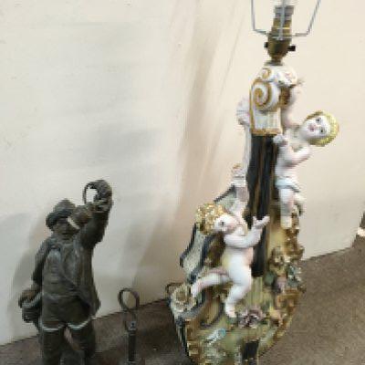 Two lamps including a spelter man holding a lantern and an Italian style cherubs surrounding a violin porcelain lamp . 50 & 83cm tall This lot cannot be posted