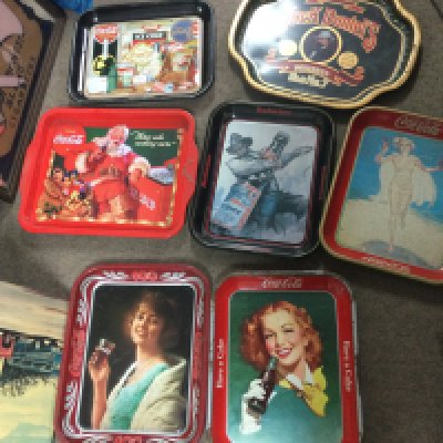 A collection of advertising trays including Coca Cola, Jack Daniels, Budweiser