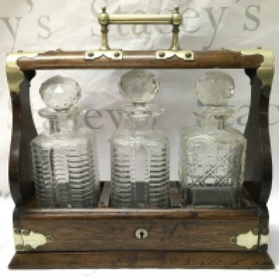 An oak and silver plated three glass decanter tantalus ,37cm wide 35cm tall. This lot cannot be posted