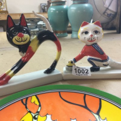 Two Art Deco style L Bailey cats together with three Wedgwood Clarice cliff plates .