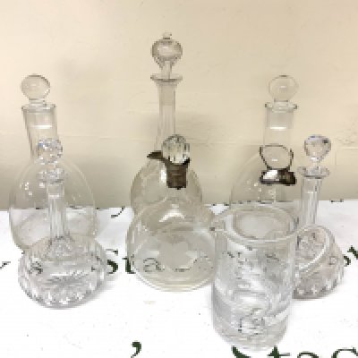 A pair of Blown glass claret jugs, a tall sherry decanter with etched floral decoration, A pair of Edwardian cut glass claret jugs, A Victorian floral etched whisky decanter with silver plated spout collar (later stopper), Atlantis cut crystal water jug.
