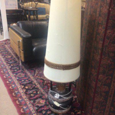 A mid 20th century floor lamp with a brown glazed ceramic base and elongated shade.
