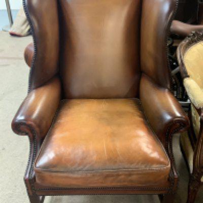 A vintage leather wing back armchair.