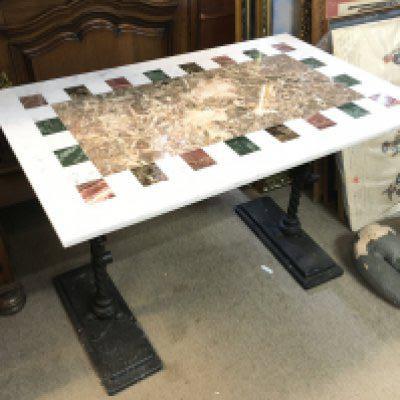 A marble top table with cast iron legs , 90cm wide, 60cm tall.