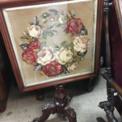 A Victorian mahogany fire screen the rectangle frame inset with a floral tapestry.