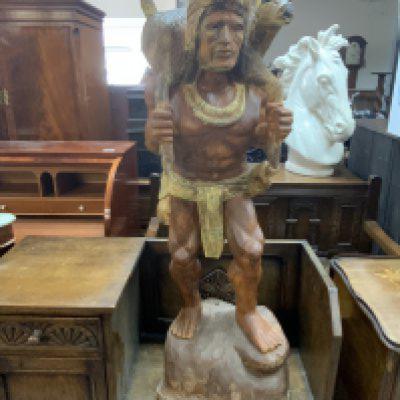 A caved hunter figure, teak and gesso. 105cm