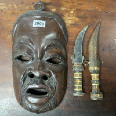 A carved hardwood tribal mask together what to bone inlaid sheathed knives.