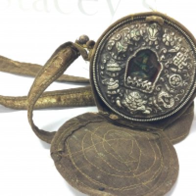 A small Tibetan travelling shrine with a silver embossed front and carrying bag . 8.5cm tall and wide.postage category B