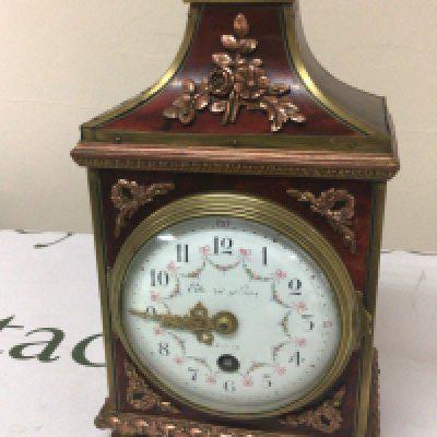 A French Clock with applied copper and brass floral ornamentation. The painted dial with garlands brass movement with key. Height 29cm