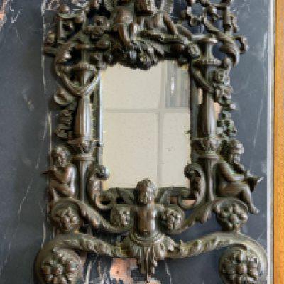 A heavy cast iron mirror/photo frame decorated with putti. 36cm ( stand missing)
