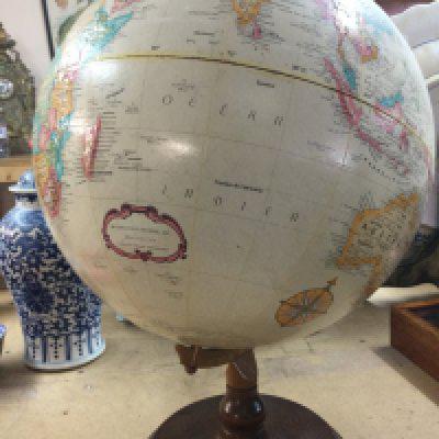 A Replogle globe on mahogany stand .