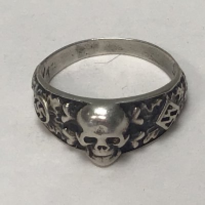 A German Third Reich SS white metal ring with raised skull the inner band with inscription.