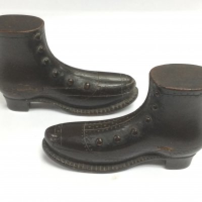 A pair of POW carved puzzle boxes in the form of boots, approx length 10cm. Shipping category A.