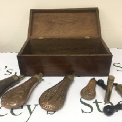 Four 19th century Copper powder flasks and cartridge loader all in a mahogany box.