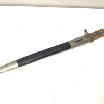 A genuine and good example of a German Third Reich Police dress bayonet with horn grip applied badge eagle top the blade with number to the edge 357 and makers stamp mark leather and metal scabbed blade has few marks condition in keeping with age.