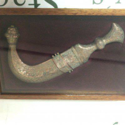 A brass Islamic Jambiya Knife from the Arabian Peninsula the scabbard and grip with perfuse folate pattern in a fitted case sealed.