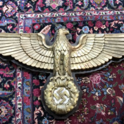 A WW2 Third Reich German eagle wall plaque with a wooden base, marble behind the swastika and the gilt eagle itself composition. 110cm wide 62cm tall approximately .This lot cannot be posted