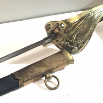 An 1827 pattern Victorian Royal British Navy Sword with a wired dark shagreen grip with brass guard with anchor and crown etched blade with further conforming decoration. Leather and brass scabbard.