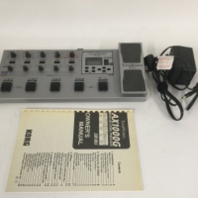 A Korg Toneworks AX1000G multi effects pedal with user manual and power lead.