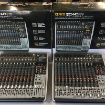 Two boxed Behringer Xenyx QX2442USB 24 input mixers.
