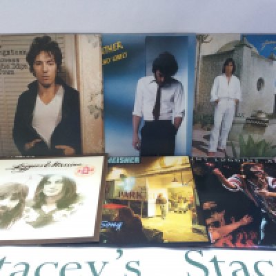 Two bags containing 22 promo copy LPs and 12" singles by various artists including Bruce Springsteen, Loggins & Messina, Carole King and others.