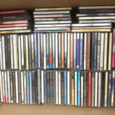 A box of CDs by various artists including David Bowie, The Pixies, Supergrass, Kings Of Leon and many more.