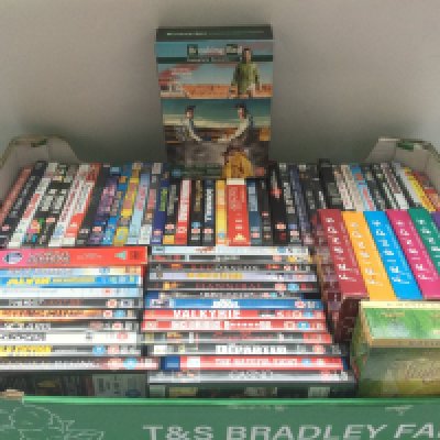 A box of DVDs comprising various movies and TV series.