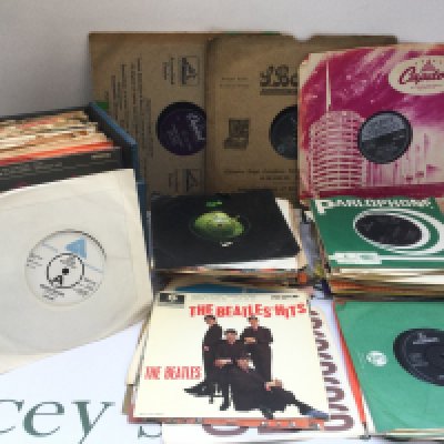 A box of 7" singles, EPs and 78s by various artists including The Beatles, Gene Vincent, Bobby Vee and others.