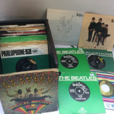 A record case of Beatles and solo 7" singles and EPs.