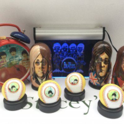 Three John Lennon Russian dolls, a set of 4 Yellow Submarine baseballs, a Beatles neon light and an alarm clock.