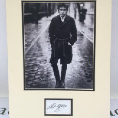 A Bob Dylan signed photo display. No COA. Please note that we are not experts in this field and can offer no guarantees that these signatures are genuine and will not be held responsible should they prove otherwise.