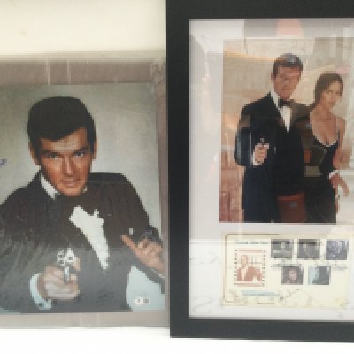 A James Bond photo signed by Sir Roger Moore, approx 27cm x 35cm with Beckett COA together with a framed and glazed First Day cover and photo display also signed by Moore (2).