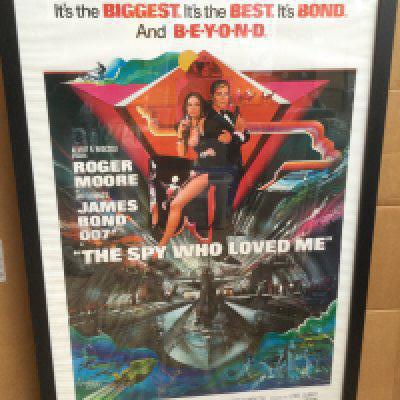 A framed and glazed James Bond film poster for 'The Spy Who Loved Me' signed by Sir Roger Moore with COA. Approx 66cm x 96cm including frame.