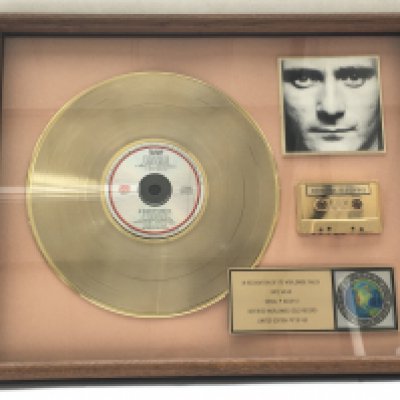 A framed and glazed limited edition gold disc, CD and cassette display in recognition for worldwide sales of the Face Value album by Phil Collins. Number 17/60. Approx 53cm x 43cm.