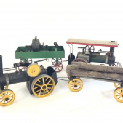 A box containing 2 Mamod steam engines each with pull along carriage.