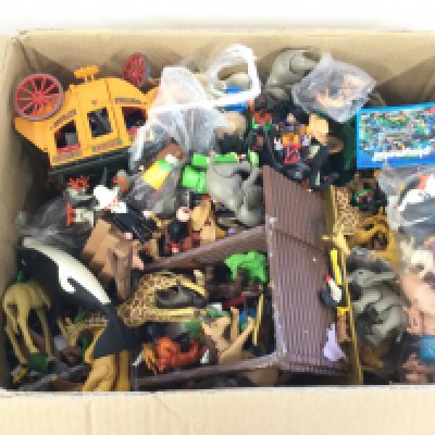 A box containing a quantity of Playmobile. Mostly animals and people.