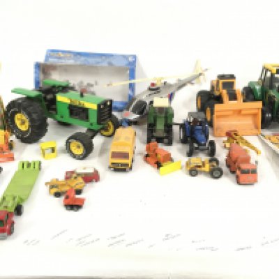 A box containing a mixed collection of Playworn diecast and plastic model vehicles by Tonka ..Buddy L and others. Also includes 2 Tomy hand held games . Plus a pair of cassettes and toy magazines