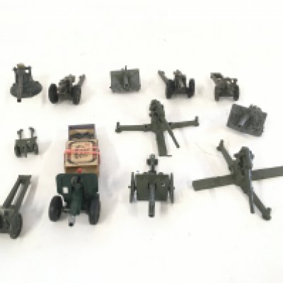 A collection of 12 military artillery guns includes some shells.