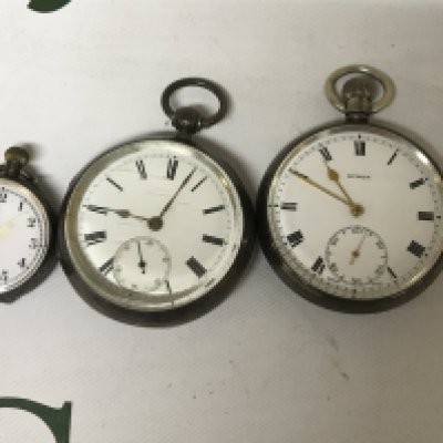 Three silver pocket watches with Roman and Arabic numerals.