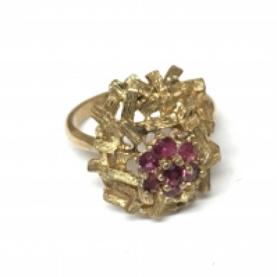An unmarked floral ring set with rubies. Size M 1/2 and 5.11g