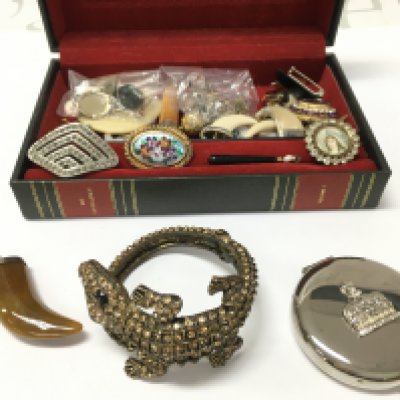 a box of interesting jewellery and other items including pendants , pins etc . Postage category B