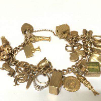 A 9ct gold charm bracelet set with assorted charms. 51g