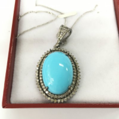 Oval pendant in white metal set with a large oval cabochon turquoise and double halo set with diamonds all on a silver chain. Postage B