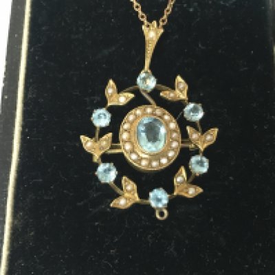 An Edwardian 9ct seed Pearl and aquamarine pendant on 9ct chain. Postage B