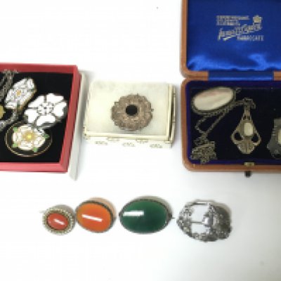 A collection of assorted silver brooches.
