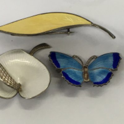 Three silver and enamel brooches butterfly and floral design.